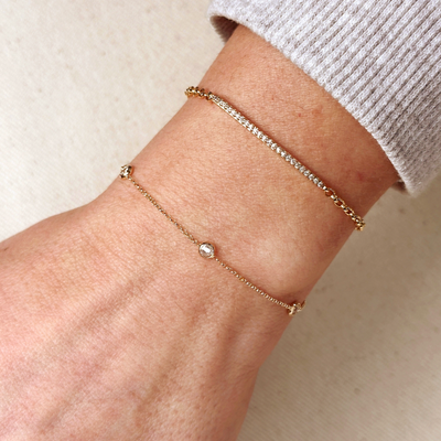 Elevate your elegance with our 18k Gold Filled CZ Bezel Bracelet, featuring sparkling cubic zirconia stones set in a delicate gold bezel. This bracelet adds a touch of luxury and sophistication to any outfit, perfect for both casual and formal occasions.