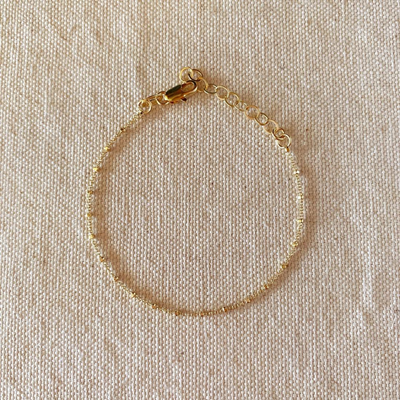 Enhance your style with our 18k Gold Filled 1mm Spaced Beaded Bracelet, featuring delicate, evenly spaced beads for a timeless and sophisticated look. Perfect for any occasion, this elegant accessory adds a touch of luxury to your ensemble.