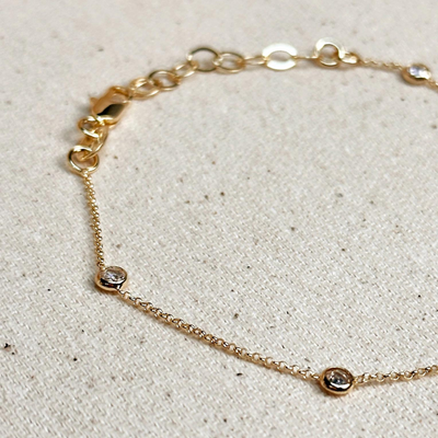 Elevate your elegance with our 18k Gold Filled CZ Bezel Bracelet, featuring sparkling cubic zirconia stones set in a delicate gold bezel. This bracelet adds a touch of luxury and sophistication to any outfit, perfect for both casual and formal occasions.